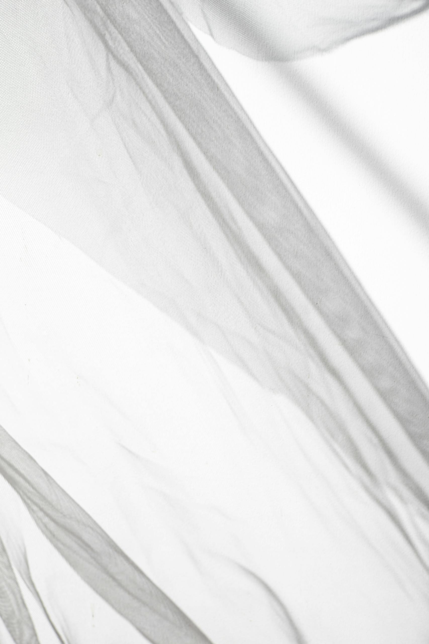 Delicate sheer fabric in black and white, creating an abstract flowing pattern.